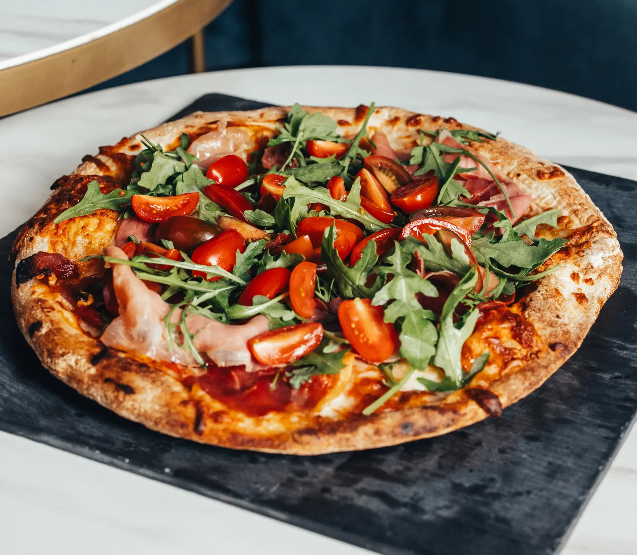 Pizza with prosciutto, cherry tomatoes and rocket at Soho